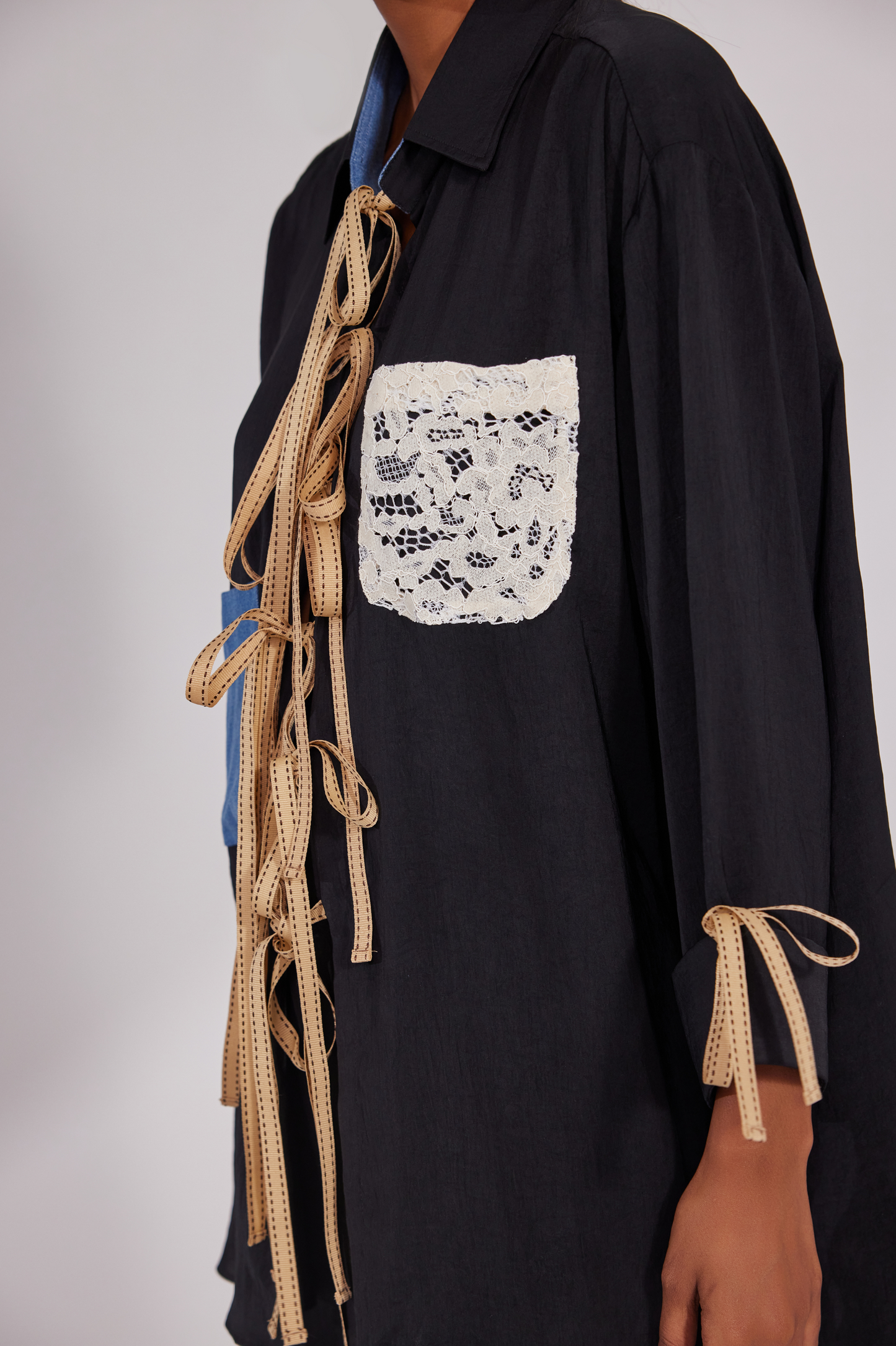 Collared shirt with ribbrons instead of traditional buttons and pockets positioned diagonally up and down with pocket pants